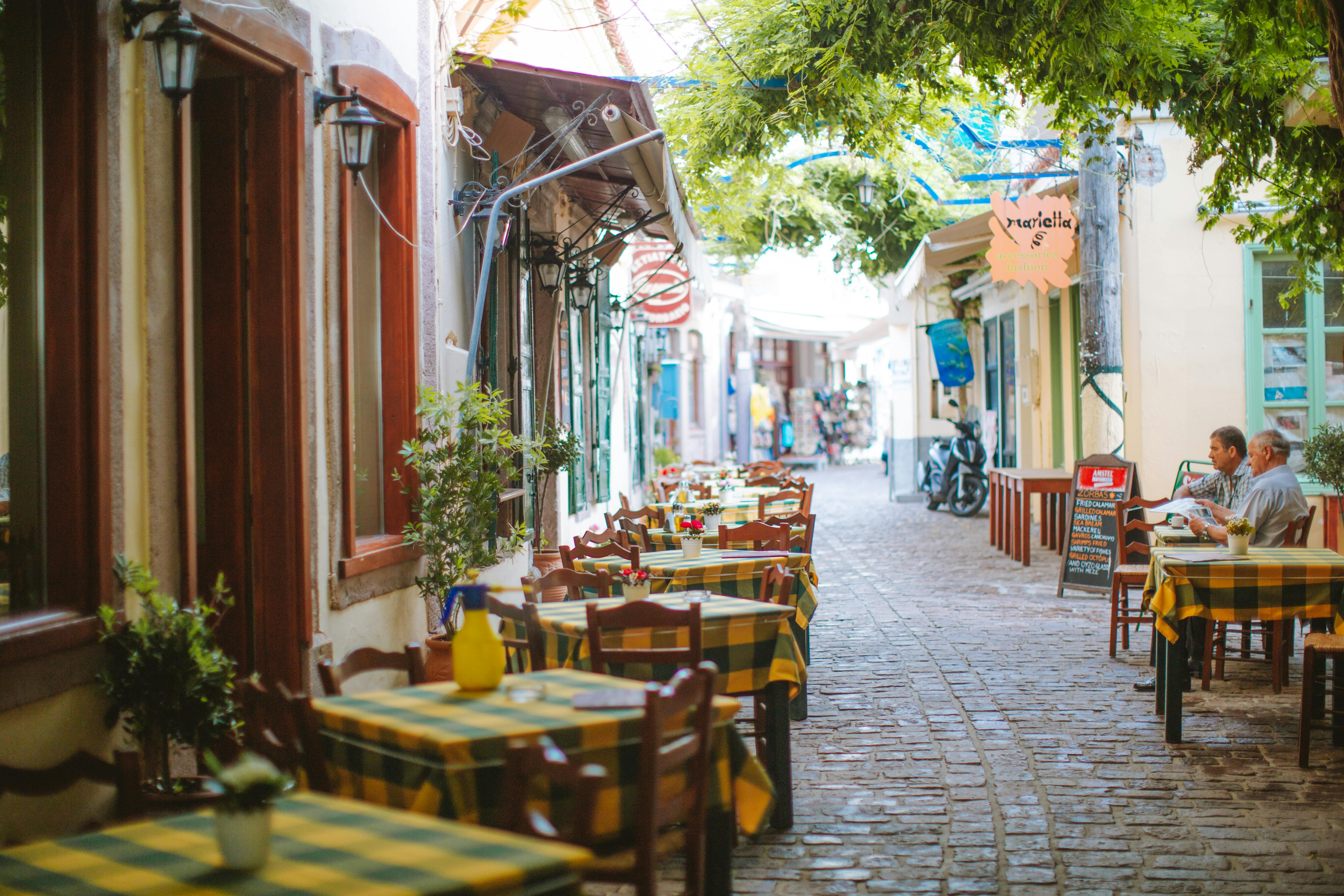 Mediterranean café street with outdoor chairs, a warm retirement abroad lifestyle scene
